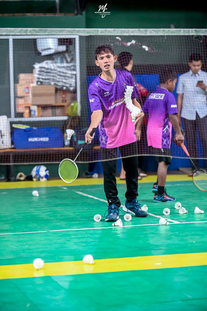 Pelatih memberi umpan kok kepada atlet saat latihan